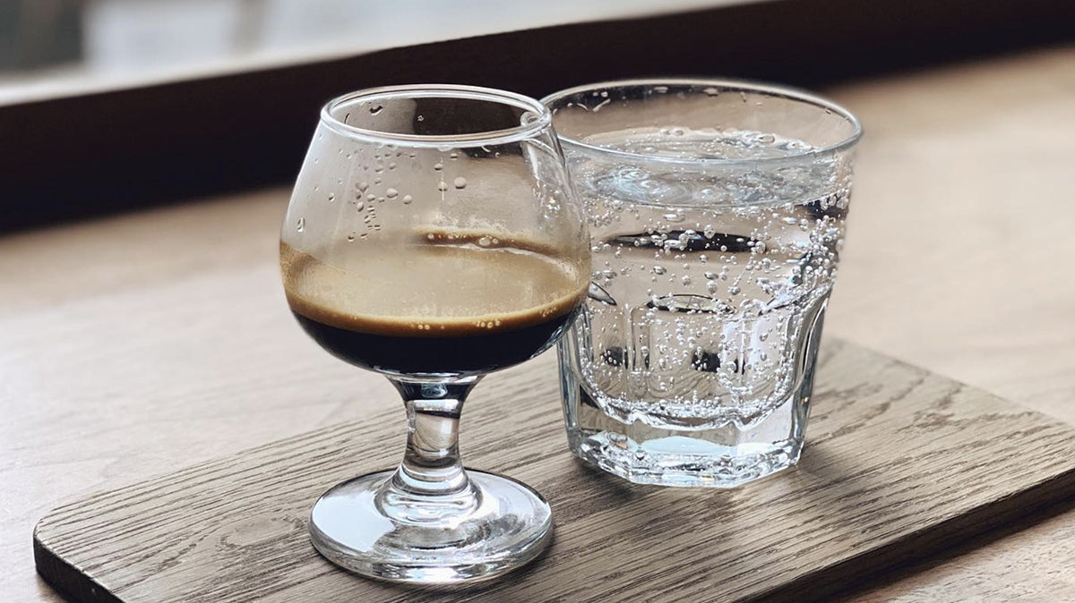 Cups of espresso and sparkling water served on a board