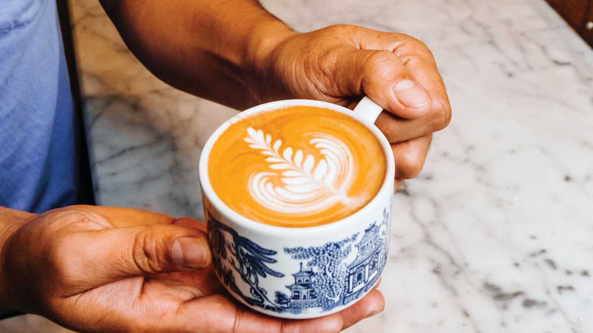 barista holding a latte