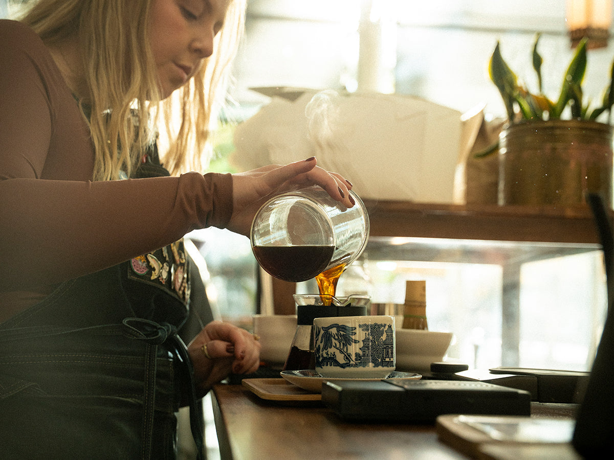 barista pouring a decaf coffee