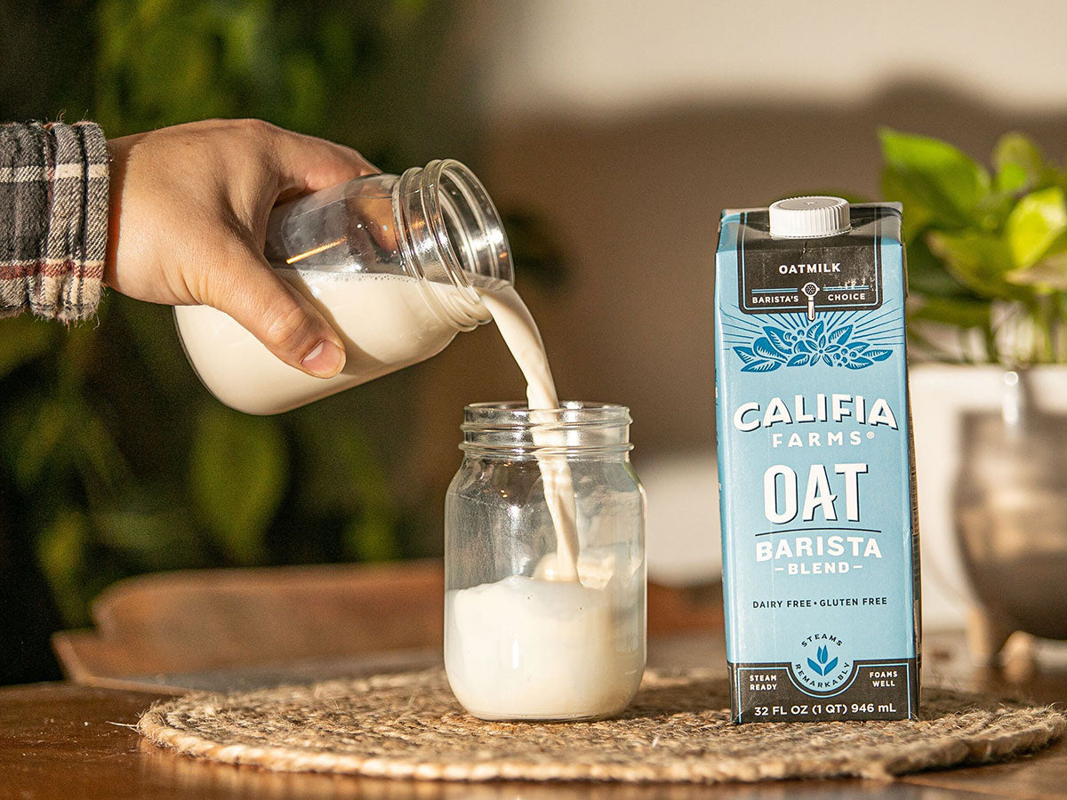 barista pouring oatmilk coffee